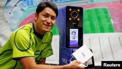 NEC Green Rockets' rugby player Teruya Goto poses with the face recognition system for Tokyo 2020 Olympics and Paralympics, which is developed by NEC corp, during its demonstration in Tokyo, Japan, Aug. 7, 2018. 