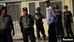 Police stand near Sule pagoda as they guard the city. Just before midnight when the crude time-bomb exploded in the ninth-floor guest room in the luxurious Traders Hotel in Rangoon, Oct. 15, 2013.