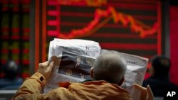 A man reads a newspaper reporting a story of U.S. President Donald Trump opening conditional dialogue with North Korean leader Kim Jong Un, at a brokerage house in Beijing, Jan. 8, 2017. Trade between China and North Korea fell 50 percent in December.