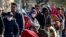 Migrants queue on a bridge crossing the border river Inn at the German-Austrian frontier between Braunau and Simbach am Inn near Passau, Germany, Nov. 1, 2015. Chancellor Angela Merkel failed to resolve differences within her ruling coalition on dealing with the crisis over a huge refugee influx, leaving open a row that has dented her conservatives' popularity. 