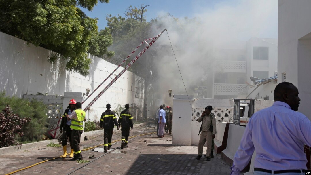Smoke and steam from fires extinguished with water, clouds the scene of a twin bombing attack on a hotel in the capital Mogadishu, Somalia, Feb. 20, 2015. 