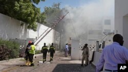 Smoke and steam from fires extinguished with water, clouds the scene of a twin bombing attack on a hotel in the capital Mogadishu, Somalia, Feb. 20, 2015. 