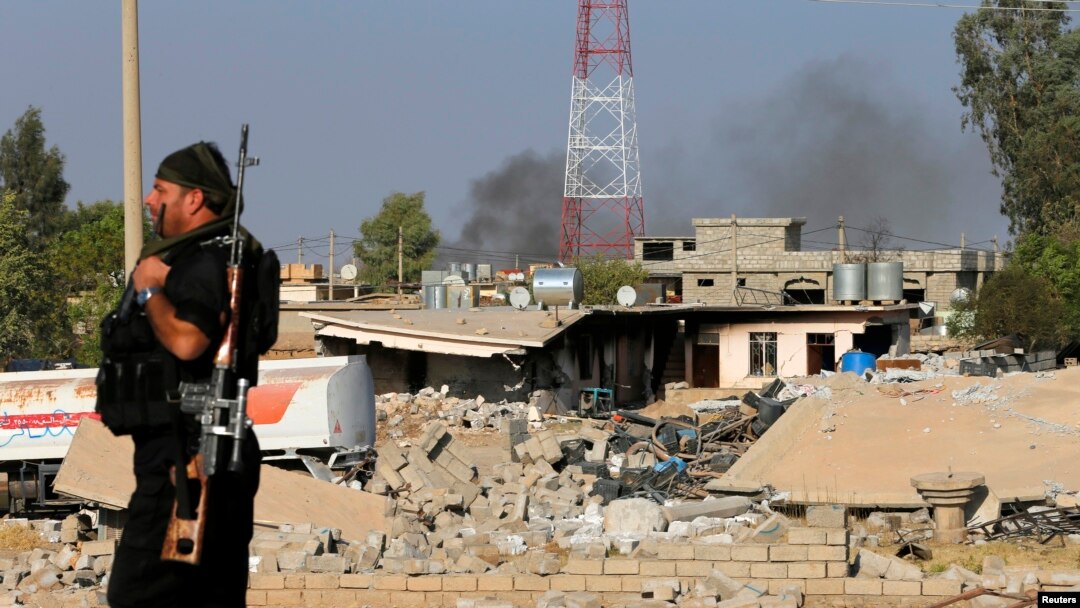 Seorang pejuang Kurdi Peshmerga melewati rumah yang hancur karena serangan udara Amerika di Zummar, yang dikontrol oleh Negara Islam (ISIS) dekat Mosul, Irak (15/9). 