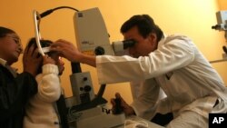 FILE - A doctor performs laser microsurgery on a 2-year-old with congenital cataracts at the Ophthalmology Institute in La Paz, Bolivia, April 26, 2006. Researchers now have discovered a technique that removes the cataracts, and stimulates a child's stem cells to regrow a functioning lens.