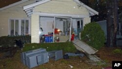 A home is damaged and its lawn is covered with debris after a tornado touched down in Mobile, Alabama, December 25, 2012.