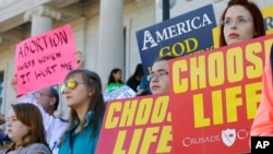 FILE - People hold signs at an anti-abortion rally at the Arkansas state Capitol in Little Rock, Ark., Jan. 18, 2015. 