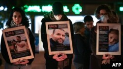 FILE - Protesters hold portraits of victims of the ongoing battles between Israel and Hamas during a rally in support of Palestinians and to demand a ceasefire, in Toulouse, southwestern France, on November 17, 2023.