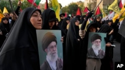 Iranski demonstranti drže postere vrhovnog vođe ajatolaha Alija Khameneija na demonstracijama za osudu ubistva vođe Hamasa Ismaila Hanijeha u Teheranu 31. jula 2024. Khamenei je optužio Izrael za atentat i obećao "oštru kaznu".