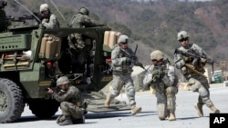 FILE - U.S. Army and South Korean soldiers take their positions during a live-fire exercise at the Rodriquez Multi-Purpose Range Complex in Pocheon, north of Seoul, South Korea, March 25, 2015. 