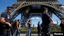 Des policiers français patrouillent autour de la Tour Eiffel à Paris, le 20 août 2016.