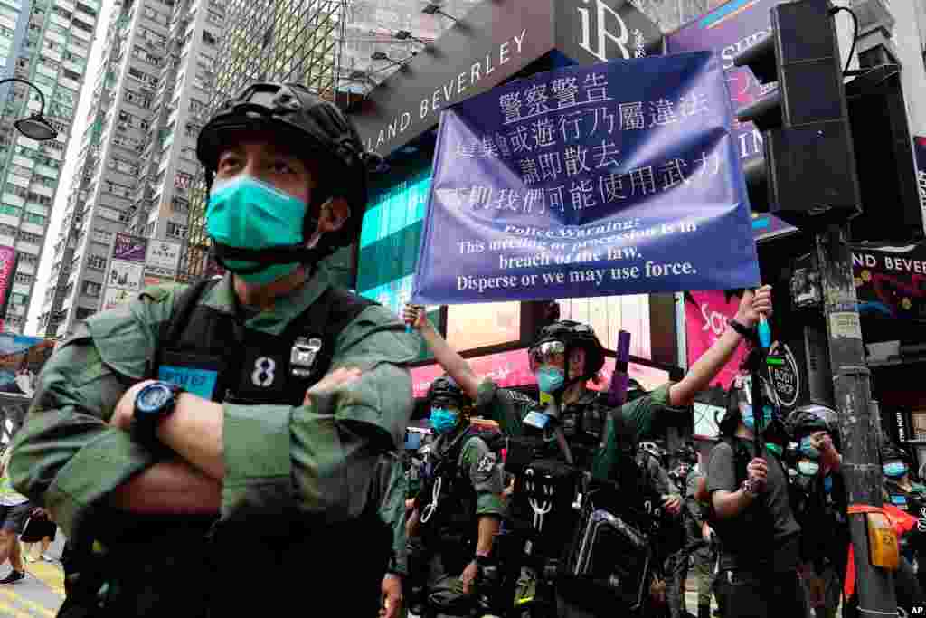 A police officer displays a warning banner on China&#39;s National Day in Causeway Bay, Hong Kong.