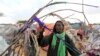 A Somali woman ties a string while constructing the roof of her makeshift dwelling after fleeing famine in the Marka Lower Shebbele regions to the capital Mogadishu, September 20, 2014. The United Nations said this month more than a million people in war-