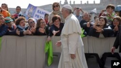 Faithful and tourists reach out to Pope Francis as he arrives for his weekly general audience, in St. Peter's Square at the Vatican, April 6, 2016. 