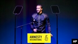 Former NFL quarterback and social justice activist Colin Kaepernick speeches after receiving the Amnesty International Ambassador of Conscience Award for 2018 in Amsterdam, Saturday April 21, 2018. Kaepernick became a controversial figure when refusing to stand for the national anthem, instead he knelt to protest racial inequality and police brutality.