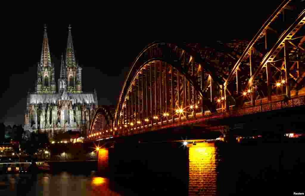 The UNESCO World Heritage Cologne Cathedral and the Hohenzollern railway bridge along the river Rhine are seen before Earth Hour in Cologne, March 30, 2019.