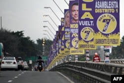 Los vehículos pasan por un puente decorado con propaganda electoral del presidente y candidato presidencial de Ecuador, Daniel Noboa, en Guayaquil, Ecuador, el 7 de febrero de 2025.