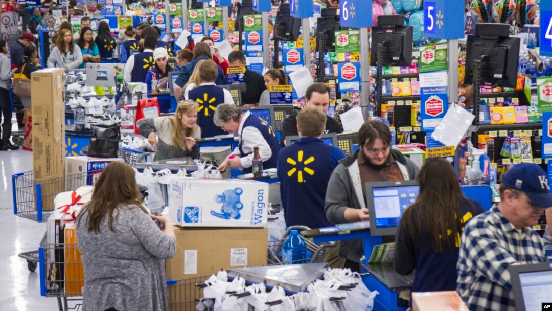 FILE - Shoppers are seen checking out at a Walmart store in Bentonville, Arkansas. Retail sales dipped 0.1 percent last month as automobile purchases fell and cheaper gasoline undercut receipts at service stations. 