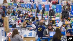 Sales clerks ring up customers at Walmart in Bentonville, Arkansas. More Americans work in retail and as cashiers than in any other occupations. (Photo by Gunnar Rathbun/Invision for Walmart/AP Images)