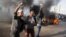 Egyptian protesters shout slogans in front of burning cars set ablaze during a demonstration calling for a "No" vote for Saturday's constitutional referendum in the coastal city of Alexandria, Dec. 14, 2012. 
