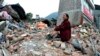 Seorang perempuan yang kerabatnya tewas akibat gempa menangis sambil duduk di atas tumpukan puing-puing di kotapraja Lingguan di kabupaten Baoxing, Provinsi Sichuan, China barat daya pada Minggu, 21 April 2013. (Foto: AP)