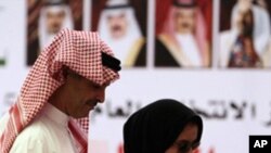 A Bahraini couple cast ballots Saturday, Oct. 23, 2010, at a general polling station set up on the Bahrain side of a bridge connecting Bahrain and Saudi Arabia. After months of street unrest, voters in the island kingdom of Bahrain were choosing a new par