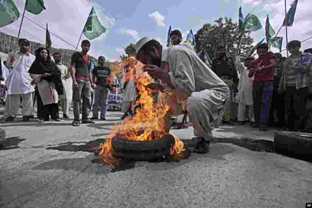 A supporter of the Pakistani religious group Jamaat-e-Islami burns a tire during an anti American rally in Abbottabad, Pakistan, May 6, 2011 (AP).