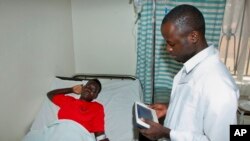 FILE - A doctor talking with a pacient at the Ntinda hospital in Kampala, Uganda.