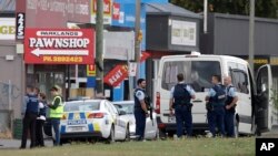 Police stand outside a mosque in Linwood, Christchurch, New Zealand, Friday, March 15, 2019