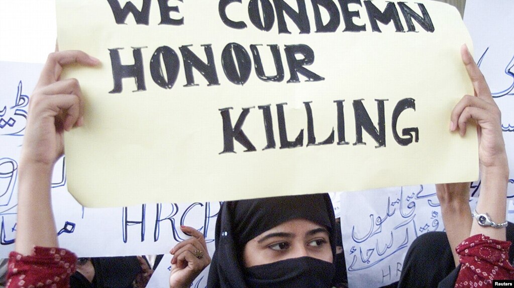 FILE - A Pakistani woman holds a placard during a protest against honor killings in Multan, Oct. 27, 2004.