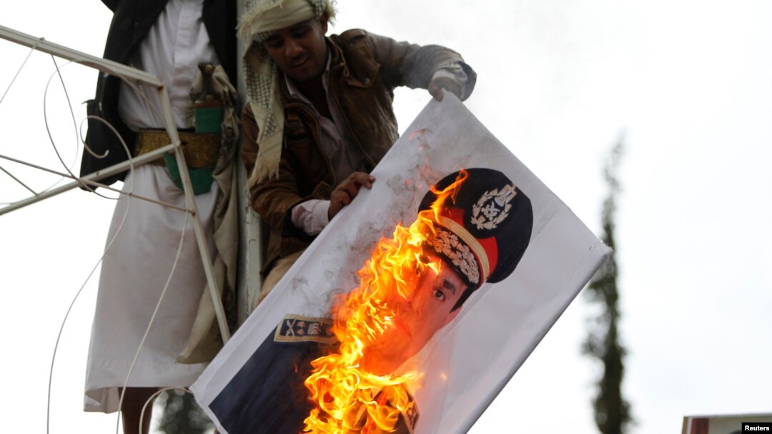 A pro-democracy protester burn an image of Lieutenant- General Abdel Fattah El Sisi, Egypt's Commanding General and Minister of Defense and Military Production, during a demonstration against what they said was a military coup that ousted Egyptian Preside