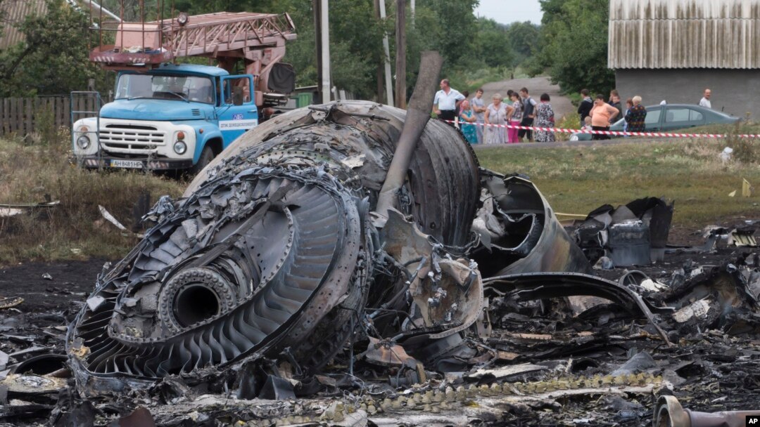 Warga lokal melihat puing-puing pesawat Malaysia MH17 yang jatuh ditembak rudal di dekat desa Rozsypne, Ukraina. Keseluruhan 298 penumpang pesawat itu tewas. 