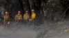 Firefighters clear trees off the road in the Palisades Fire zone in the Pacific Palisades neighborhood of Los Angeles, California, Jan. 17, 2025.