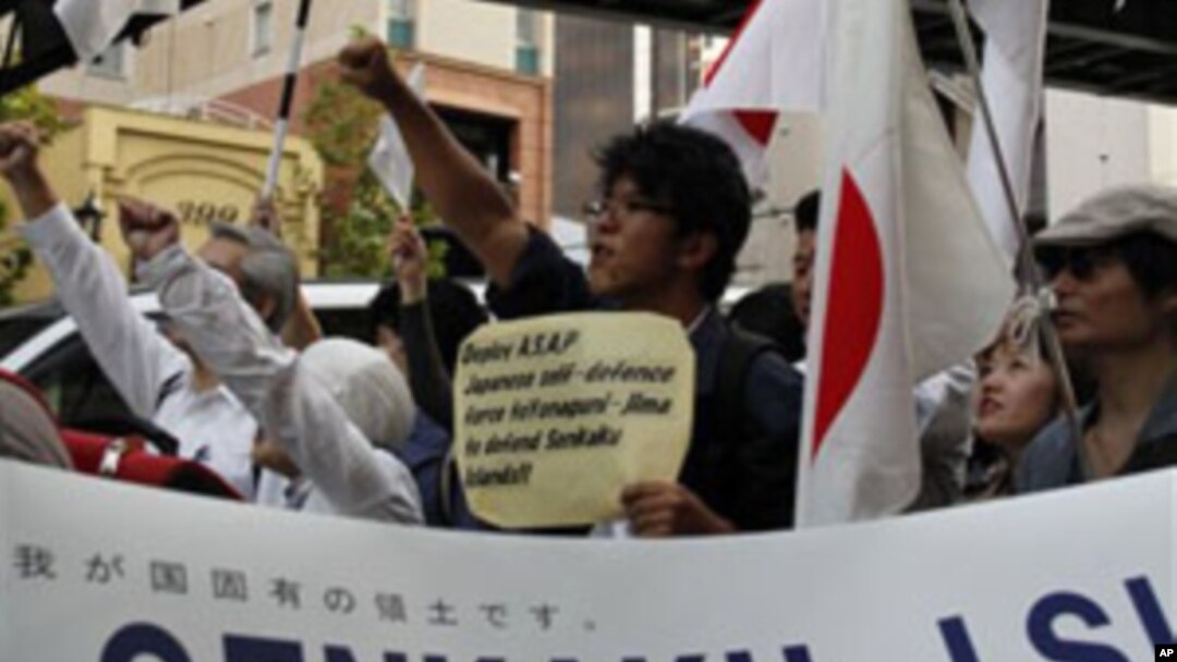 Japanese protesters spreading a banner with a message reading, "Senkaku Islands are Japanese Territories," march down streets in central Tokyo as an estimated 2,500 protesters take to the streets during a protest against China, 16 Oct 2010