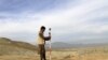 FILE - A man works at a road construction site, which is being built by a Chinese company, in Khogyani district of Nangarhar province, Nov. 19, 2015. 