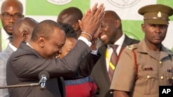 Uhuru Kenyatta, left, claps after he was announced the winner in the rerun of presidential election at the Centre in Bomas, Nairobi, Kenya, Oct. 30, 2017. 