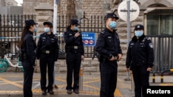 北京警察在庭审加拿大前外交官康明凯(Michael Kovrig)的法院外戒备。（2021年3月22日）