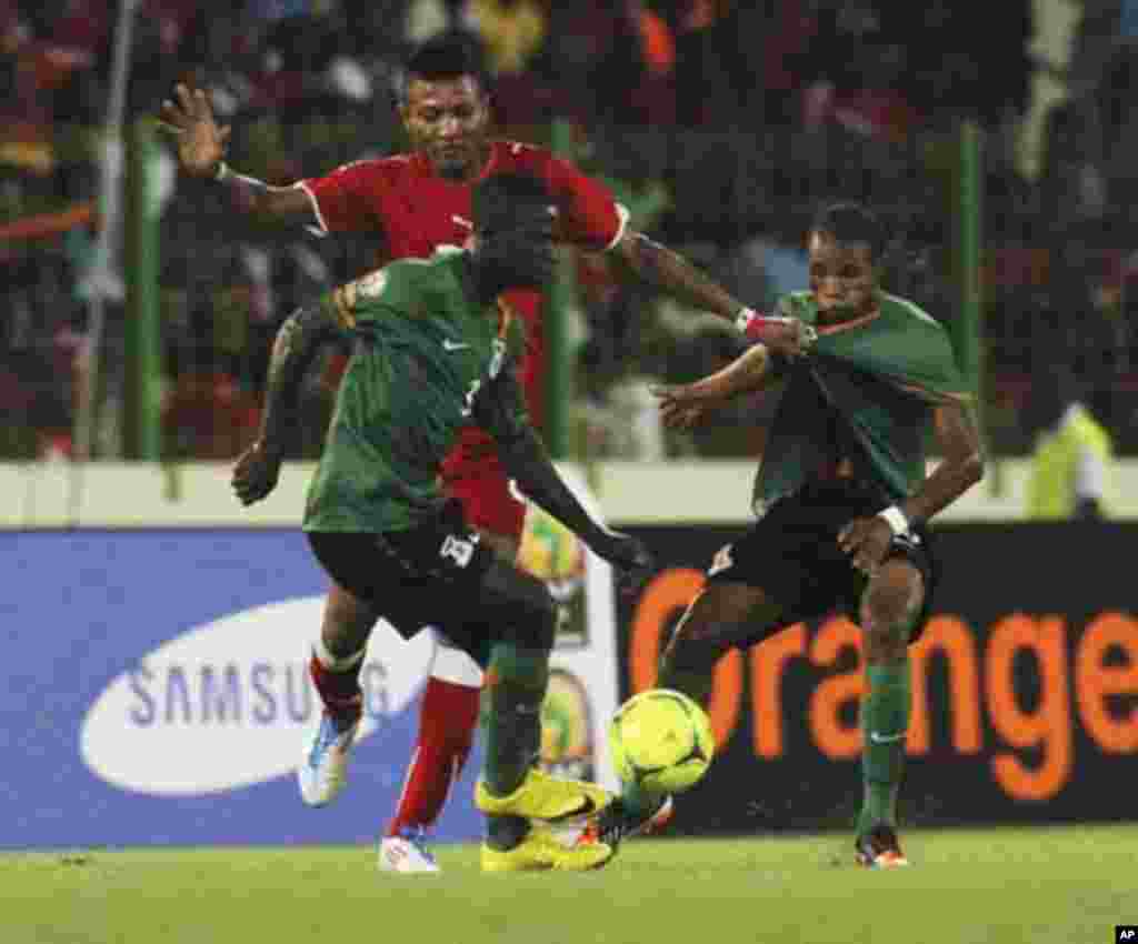 Chisamba Lungu (front) of Zambia controls the ball next to teammate Davies Nkausu (R) and Bladmir Ekoedo of Equatorial Guinea during their African Nations Cup soccer match in Malabo January 29, 2012.