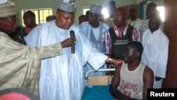 Borno State Governor Kashim Shettima, center, visits injured victims of heavy fighting at a hospital in Baga, Nigeria, April 21, 2013.