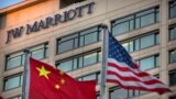 FILE - Chinese and American flags fly outside of a JW Marriott hotel in Beijing, Jan. 11, 2018. 