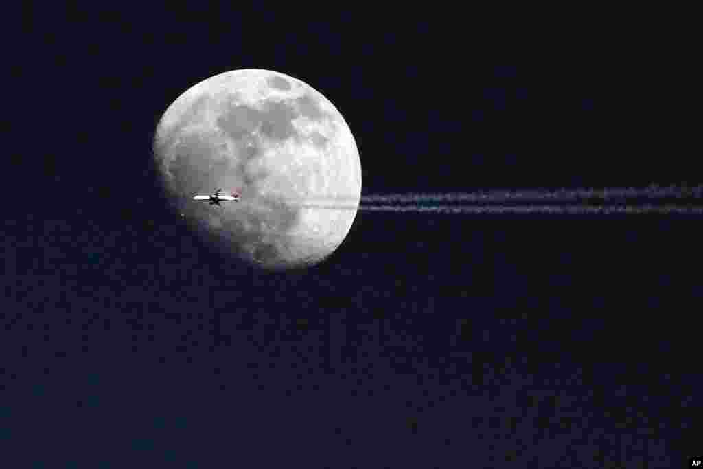 An airplane passes in front of the moon over Philadelphia, Pennsylvania, USA, May 21, 2013.