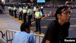 20일 홍콩 시위대가 몽콕 거리를 재점거한 가운데, 경찰이 주변을 지키고 있다. 
