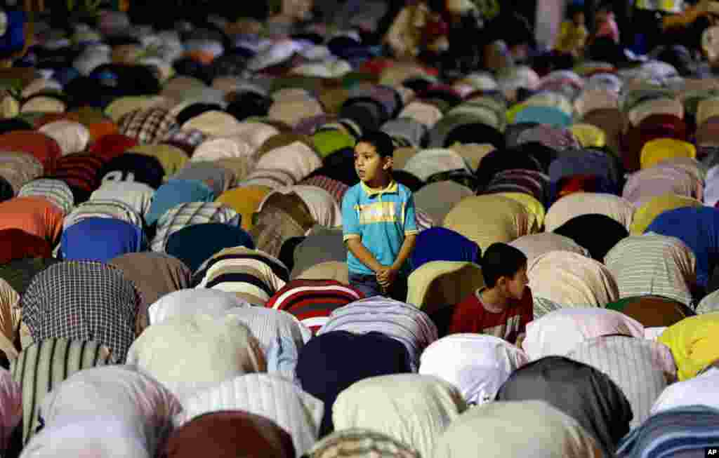 An Egyptian boy stands among Morsi supporters who are offering the Tarawih prayer after the evening meal during Ramadan, in Nasr City, Cairo, July 10, 2013. 