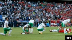 Les joueurs de l’Irlande du Nord essoufflés après le coup de sifflet final du match des huitièmes des finales de l’Euro 2016 qu’ils ont remporté 1-0 contre l'Irlande du Nord au Parc des Princes à Paris, France, 25 juin 2016.