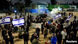 Manifestantes israelíes sostienen banderas mientras se manifiestan frente a las oficinas de la UNRWA en Jerusalén, en medio del conflicto entre Israel y el grupo islamista palestino Hamás, el 5 de febrero de 2024. 