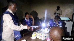 Officials of Congo's National Independent Electoral Commission (CENI) count cast ballots at a polling station in Kinshasa, Democratic Republic of Congo, Dec. 30, 2018.