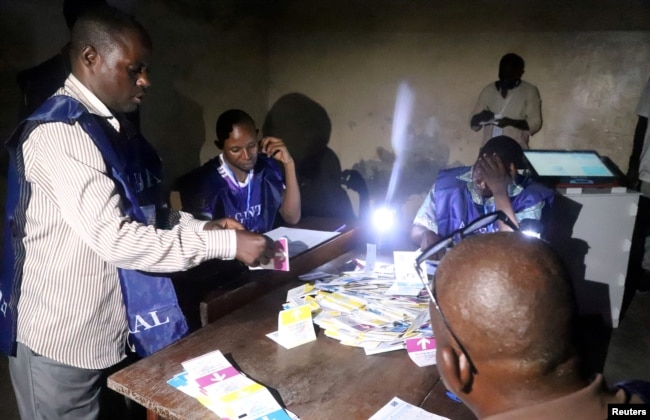 Officials of Congo's National Independent Electoral Commission (CENI) count cast ballots at a polling station in Kinshasa, Democratic Republic of Congo, Dec. 30, 2018.
