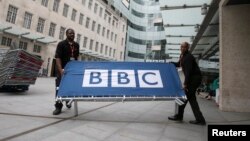 FILE - BBC workers place barriers near to the main entrance of the BBC headquarters and studios in Portland Place, London, July 16, 2015. Britain stepped back from cutting the size and scope of the BBC on May 12, 2016, after the publicly-funded broadcaster and some of its biggest stars had accused ministers of threatening the independence of the 94-year-old institution.