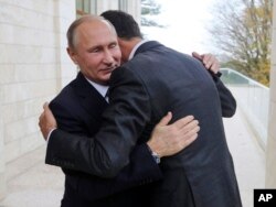 Russian President Vladimir Putin (L) embraces Syrian President Bashar Assad in the Bocharov Ruchei residence in the Black Sea resort of Sochi, Russia, Nov. 20, 2017.