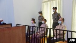 This handout photo taken on May 24, 2021 and released by Myanmar's Ministry of Information on May 26 shows detained civilian leader Aung San Suu Kyi (L) and detained president Win Myint (C) during their first court appearance in Naypyidaw
