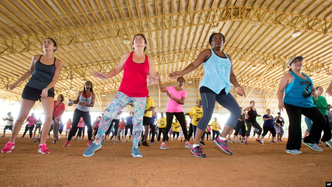 FILE - Fitness enthusiasts run through dance exercises as they work out at Tropical Park in Miami, Florida, July 25, 2015.